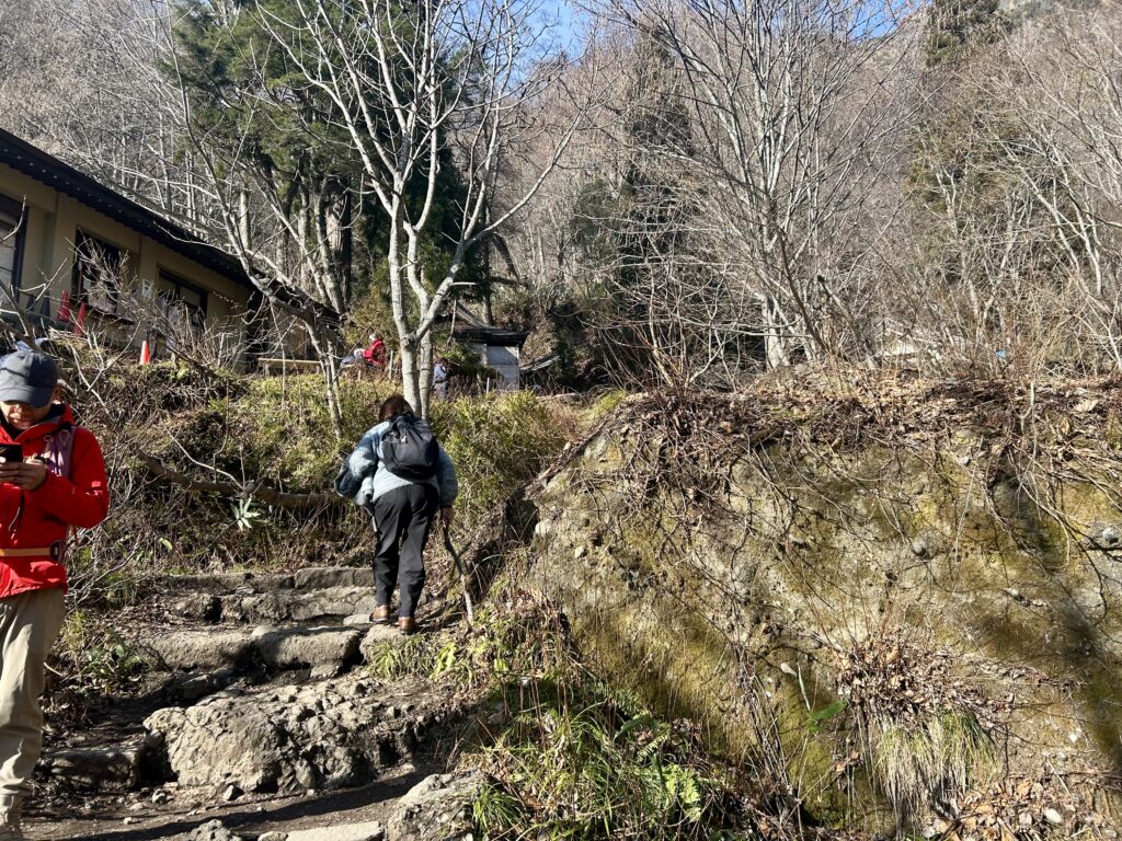 奥社到達間近。木の枝を杖代わりに使う姿も